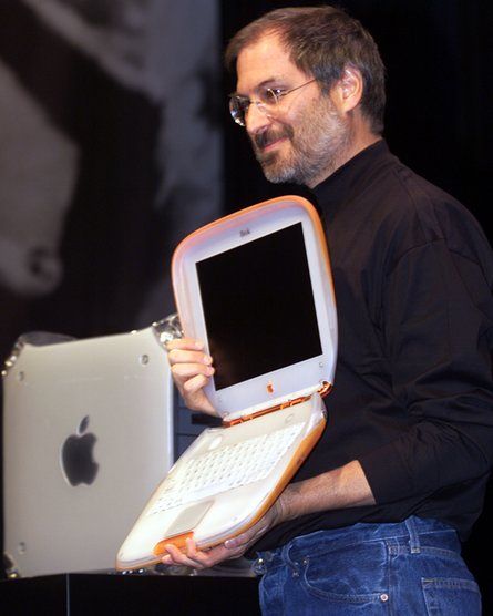 Steve Jobs on stage with an iBook, walking and using Wi-Fi, with a
"surprised" crowd.